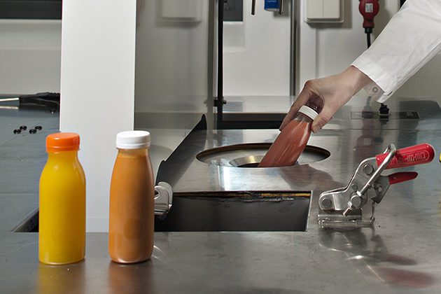 Bottles of juice being processed with high pressure in Nofima's research facility.